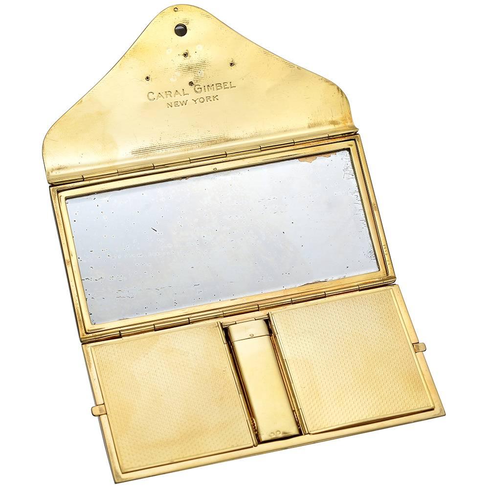 Rectangular-shaped vanity compact in engine-turned yellow gold, with a diamond-set 'C' at front inlaid in a carved lapis plaque, hinged with cabochon-cut sapphire, the compact opening to reveal a mirror on one side, engraved 'CARAL GIMBEL NEW YORK'.
