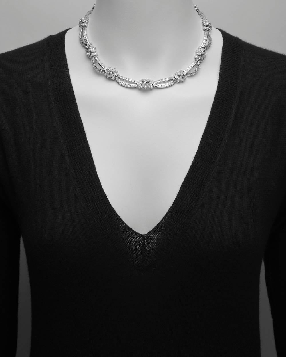 Diamond collar necklace, composed of baguette-cut diamond 'draped'-style links alternating with round-cut and marquise-shaped diamond cluster links, in 18k white gold. Baguette-cut diamonds weighing approximately 13.08 total carats, marquise-shaped