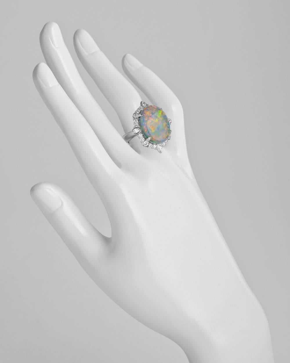 Cocktail ring, centering an oval-shaped opal weighing approximately 11.11 carats and measuring 19 x 15mm, the opal surrounded by round-cut and marquise-shaped diamonds weighing approximately 1.08 total carats, in platinum. Size 6.5 (resizable to