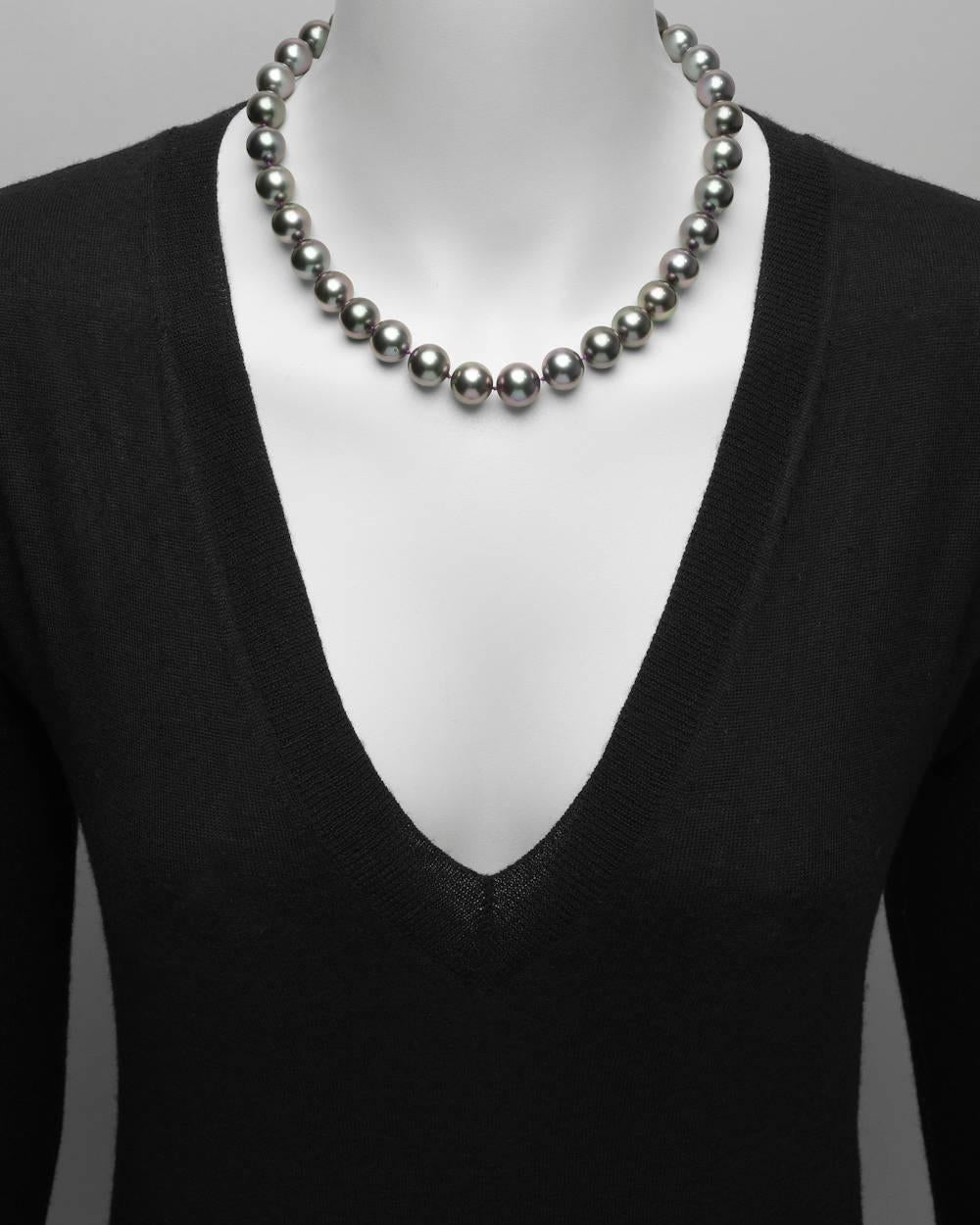 Tahitian pearl necklace, composed of 33 dark gray cultured Tahitian pearls with pink overtones ranging from 13.2 to 12mm in diameter and strung on a silk cord, secured by an oval-shaped clasp pavé-set with 120 round brilliant-cut diamonds weighing
