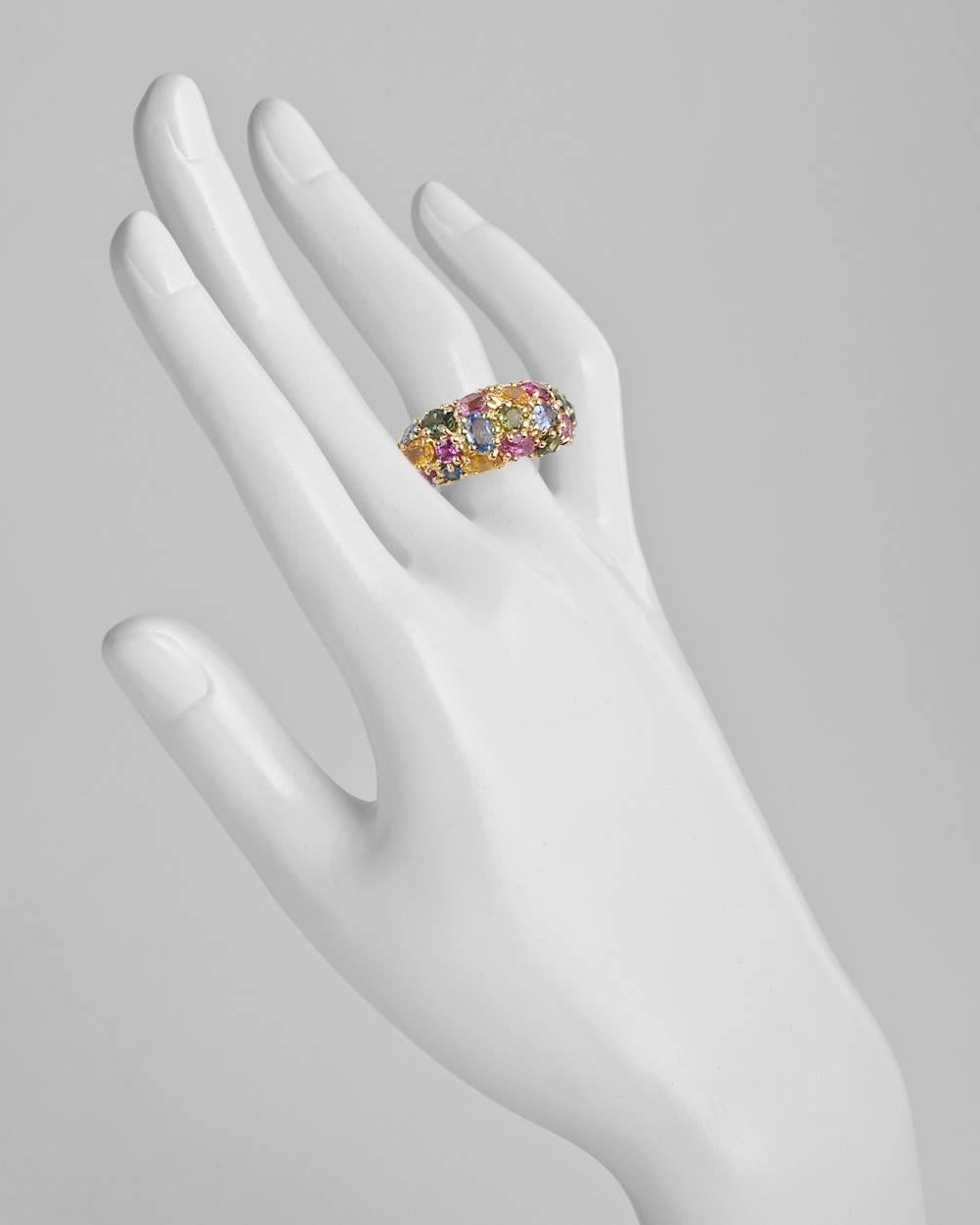 Multicolored sapphire wide band ring, showcasing round and oval-shaped sapphires in blue, green, pink and yellow hues, mounted in 18k yellow gold, signed Chaumet. Sapphires weighing approximately 6.00 total carats. Size 6.
