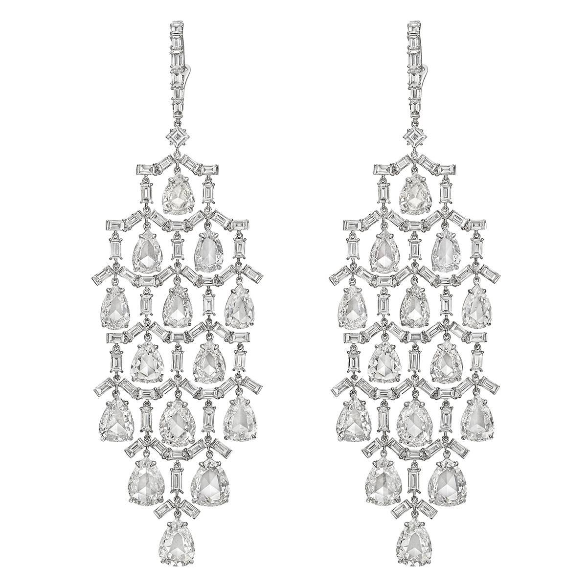 Long chandelier earrings, featuring an elegant lattice of baguette-cut diamonds suspending pear-shaped diamond drops, in platinum. Diamonds weighing 14.13 total carats. Platinum wires with hinged enclosures. 3.14