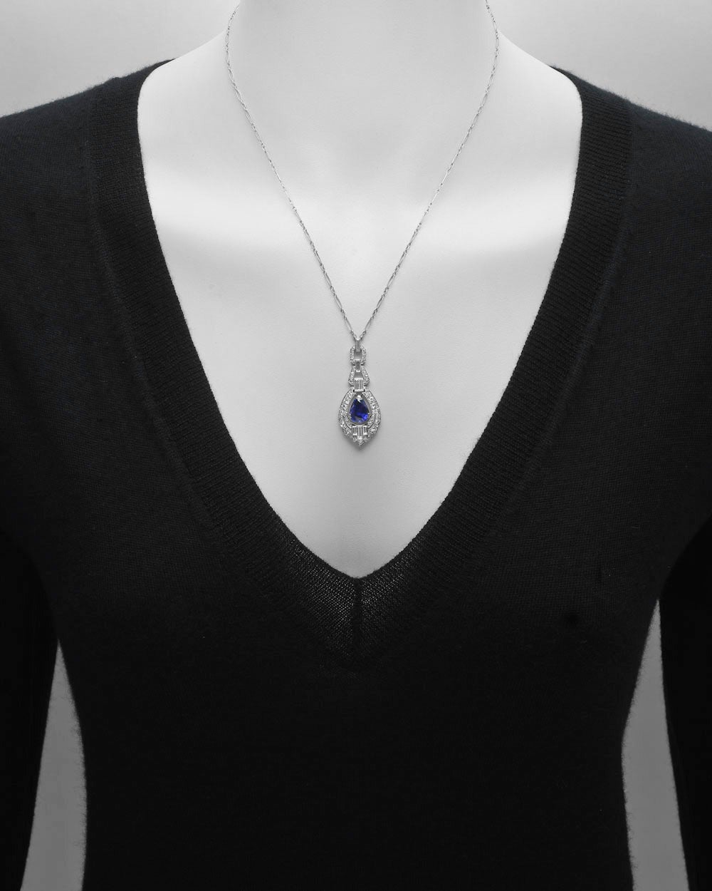 Late Deco sapphire and diamond pendant necklace, the pendant centering on a natural pear-shaped sapphire weighing 3.86 carats, within a geometric frame set with baguette-cut and circular-cut diamonds, the diamonds weighing approximately 1.82 total