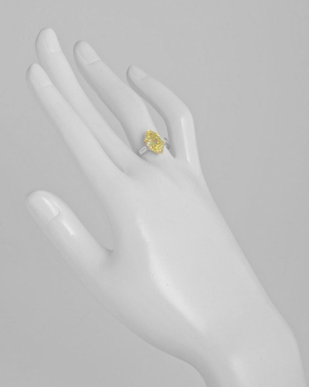 Diamond engagement ring, centering on a natural fancy vivid yellow diamond weighing 2.59 carats, flanked by two near-colorless baguette-cut diamond shoulders weighing 0.32 total carats (G-H color/VVS1-VVS2 clarity), mounted in platinum with an 18k