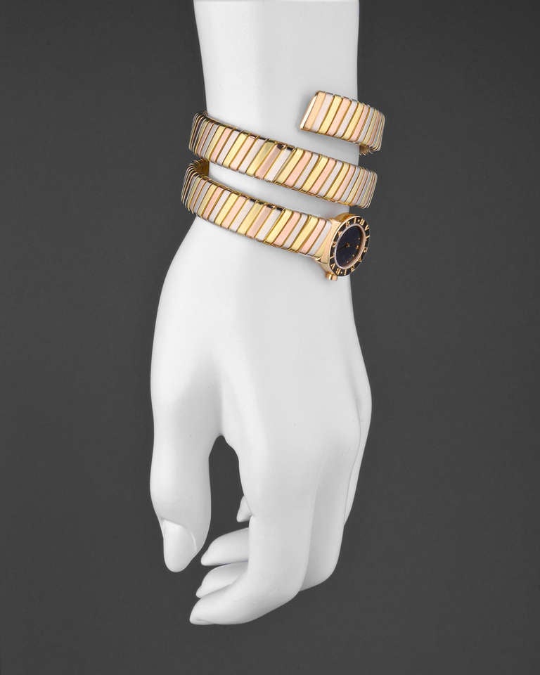 Bulgari 18k tri-colored gold Tubogas bracelet watch, featuring a quartz movement, black dial with gold hands and hour markers, 20mm, 18k yellow gold case on a Tubogas two-twirl tri-colored tension bangle bracelet.