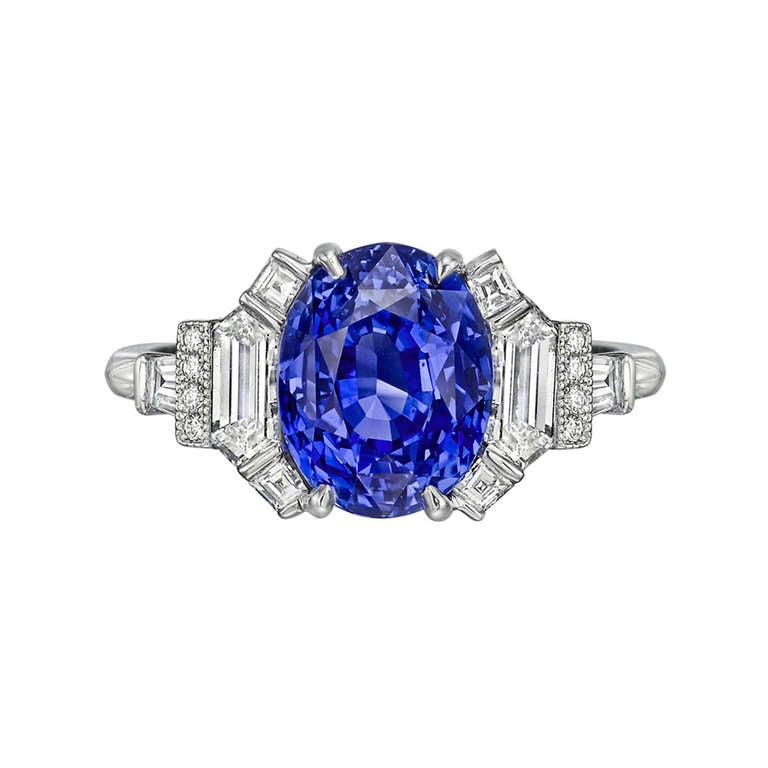 Sapphire ring in a fancy platinum setting with diamond shoulders. Oval-shaped sapphire weighing 4.20 carats (certified: natural, no indications of heat treatment) flanked by trapeze-cut, baguette-cut and round-cut diamond accents, the diamonds