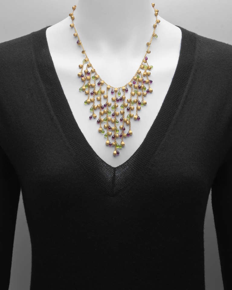 Fringe necklace, designed with graduated drops suspending peridot, garnet and textured gold beads on a gold cable chain necklace, in 18k yellow gold, signed Marco Bicego. 18