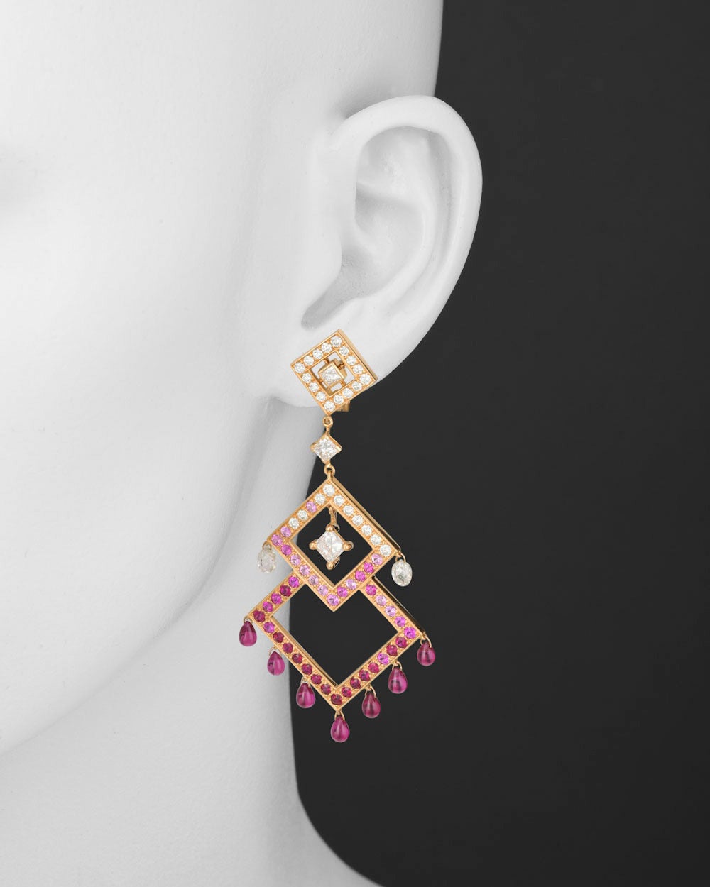 These stunning and dramatic chandelier earrings are composed of three graduated diamond-shaped frames, set with a combination of diamonds, rubies and pink sapphires, with individual diamond briolettes and ruby drops dangling gracefully from the