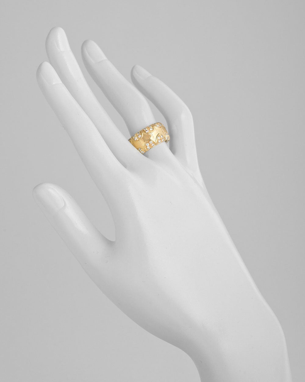 Wide band ring, designed from polished yellow gold 'panels' with a pavé diamond scalloped trim, in 18k gold, the band measuring approximately 10.5mm in width, numbered 35483, signed Boucheron. Size 6.75.