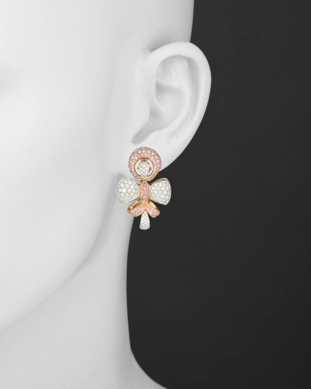 Pink and white diamond earclips, in an unusual double bow motif design showcasing a delicate balance of pink diamonds set in 18k pink gold and white diamonds set in 18k white gold, the pink diamonds weighing approximately 3.85 total carats and white