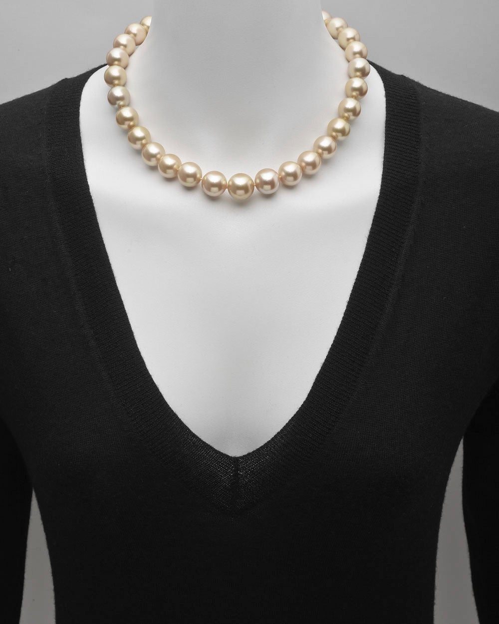 Golden South Sea pearl necklace, composed of 31 naturally golden-colored South Sea pearls ranging from 13 to 15mm in diameter, strung on a hand-knotted silk cord, with an 18k yellow gold screw-in ball clasp pavé-set with round diamonds, the diamonds