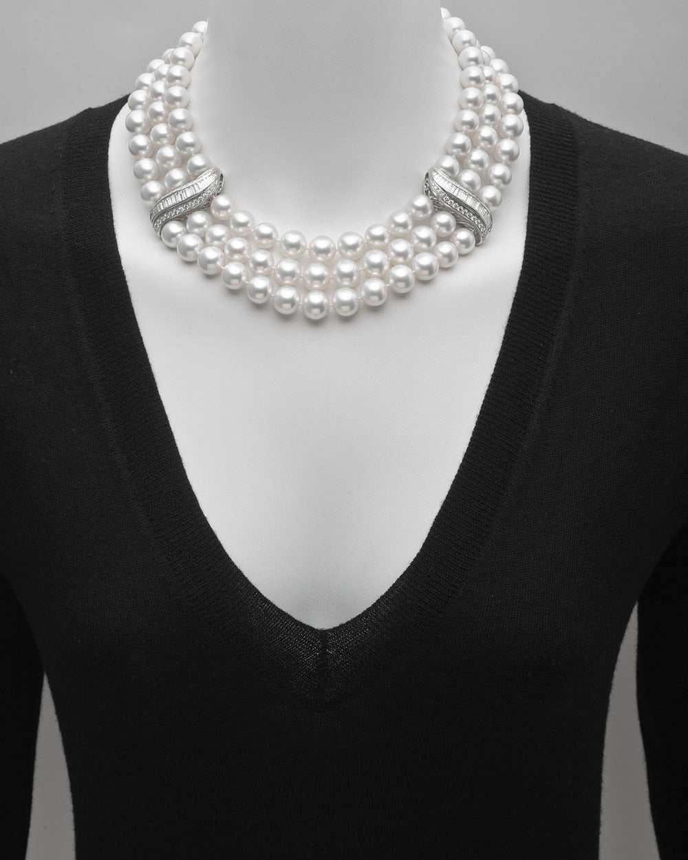 South Sea pearl and diamond panel necklace, composed of three-strands of cultured South Sea pearls, the pearls ranging from 12.4 to 10.1mm in diameter and strung on a hand-knotted silk cord, with two platinum and diamond-set panel sections and