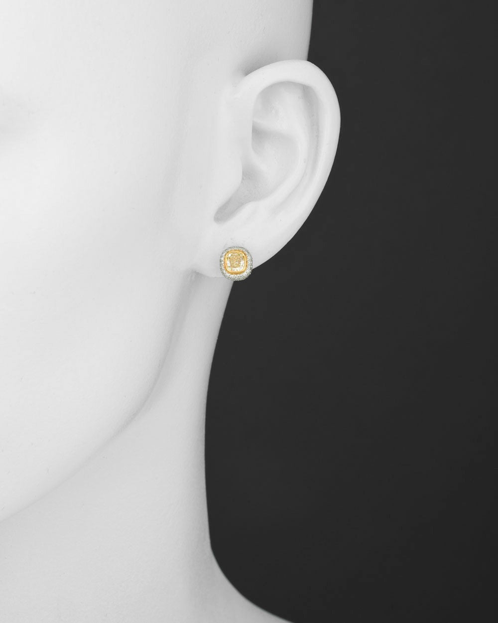 Small fancy yellow and white diamond cushion-shaped earstuds, of bombé design, centering a pair of fancy yellow diamonds weighing approximately 0.84 total carats, within a three-row white pavé diamond surround (+/-0.35ct), mounted in platinum and