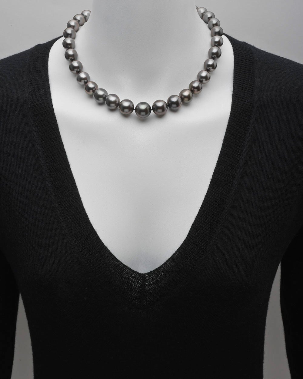 Single strand black cultured pearl necklace, composed of 33 pearls, ranging from 12-14.8mm in diameter, strung on a silk cord, with a pavé diamond ball clasp, set with approximately 4.98 total carats of diamonds and mounted in platinum. 18.5