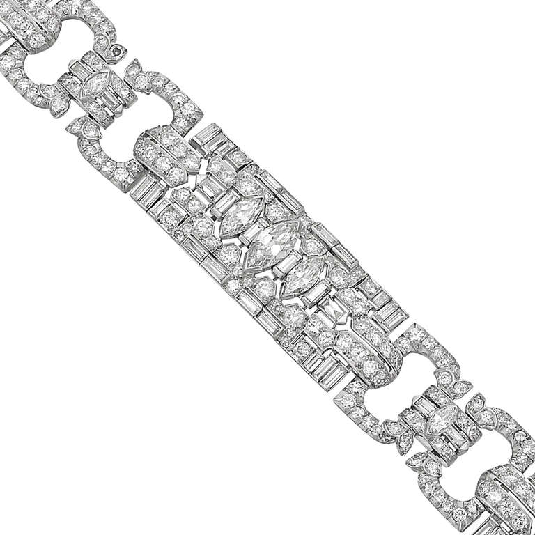 Art Deco-style diamond panel link bracelet, designed with three rectangular-shaped larger panels set with marquise-shaped, baguette-cut and circular-cut diamonds, the rectangular panels connected by double open oval-shaped links set with
