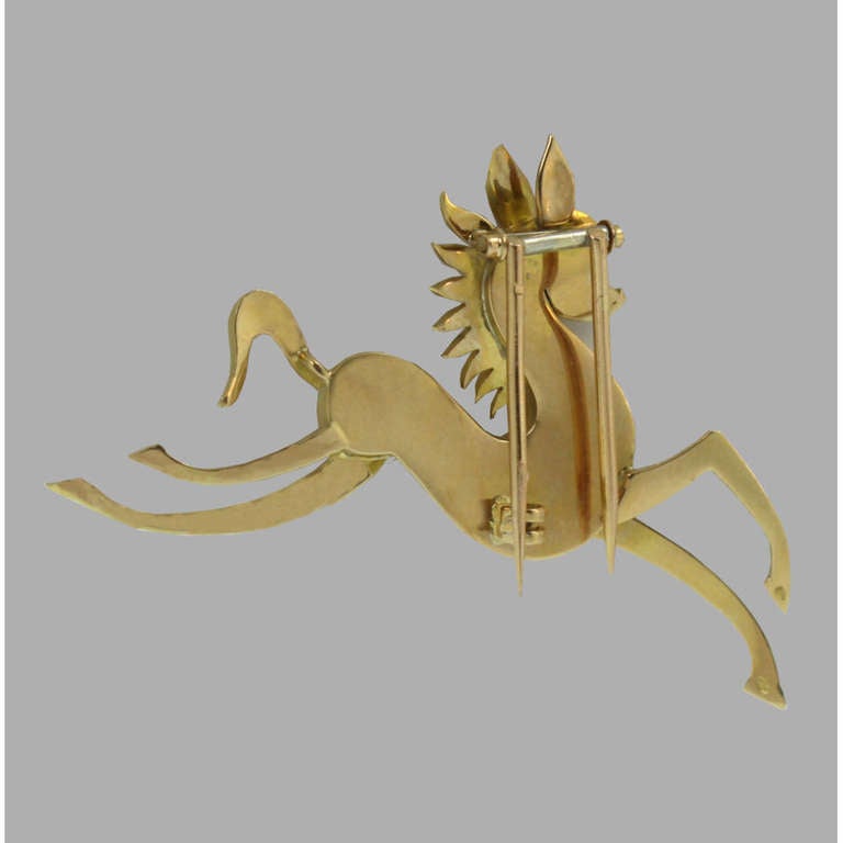 Stylized prancing horse brooch, with whimsical ears and a sunburst-like mane, as well as a single ruby eye, in 18k yellow gold, circa 1940's, made in France. 1.25