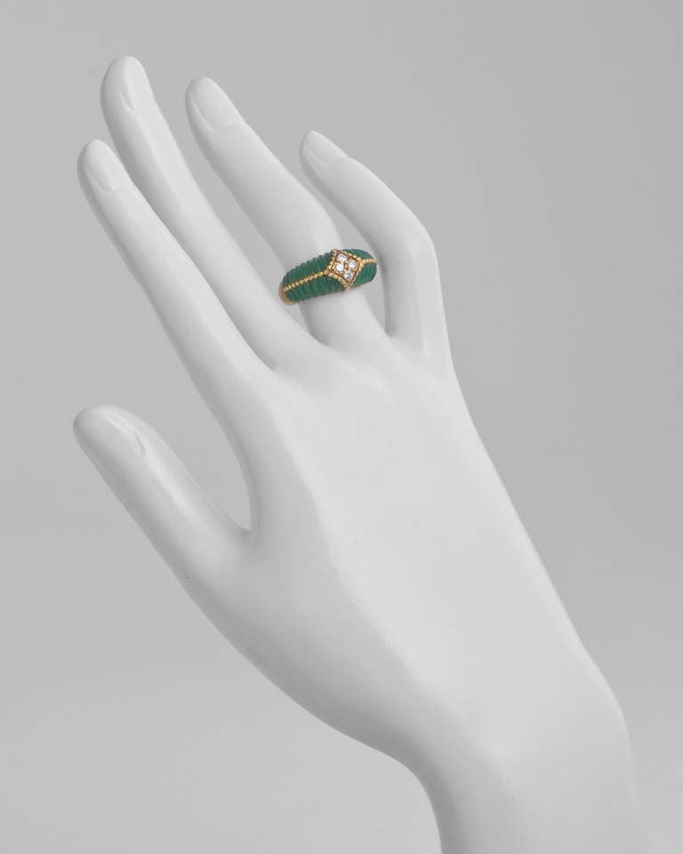 Vintage band ring, of ridged design, centering on four full-cut round diamond accents, flanked by carved sections of dark green chrysophrase, mounted in 18k yellow gold, circa 1977, numbered B5056 C23, signed 