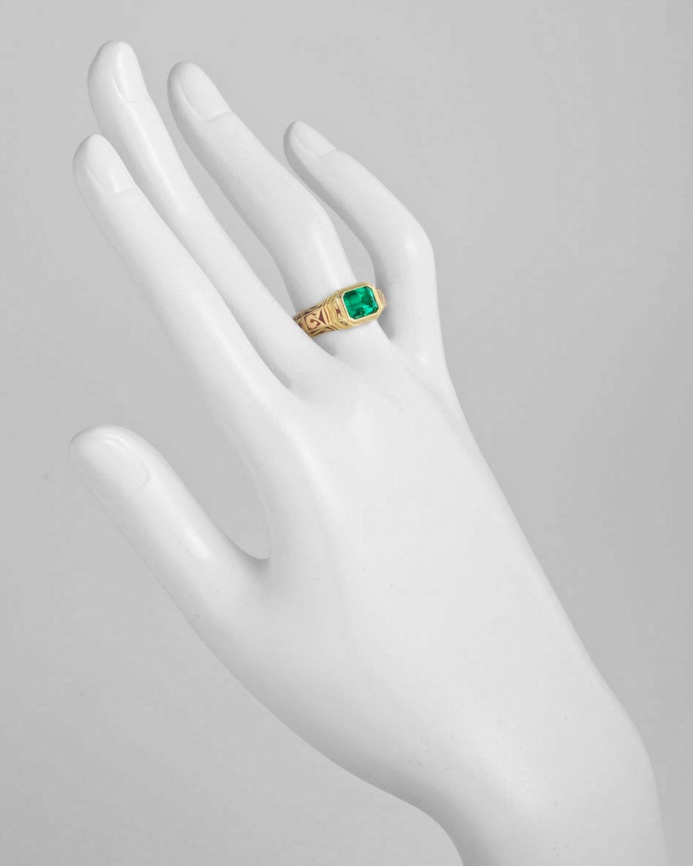 Emerald dress ring, showcasing an emerald-cut Colombian emerald weighing approximately 1.50 carats, bezel-set in 18k yellow gold, the mounting decorated with elegantly patterned reddish-brown enamel, signed Otto Jakob. Size 6.5.