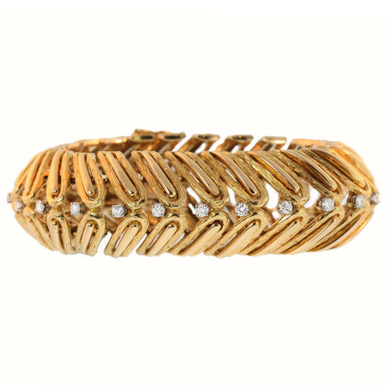 Retro gold link bracelet, formed by two rows of angled gold “paper clip” shapes with a line of delicate circular-cut diamonds running down the center, the diamonds weighing approximately 2.40 total carats, mounted in 18k yellow gold, made in France,