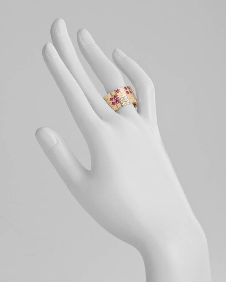 Lanières wide band ring, designed as a continuous sequence of square motifs, accented by a geometric pattern of round diamonds and rubies to the front, the diamonds weighing approximately 0.20 total carats, mounted in 18k yellow gold, the band