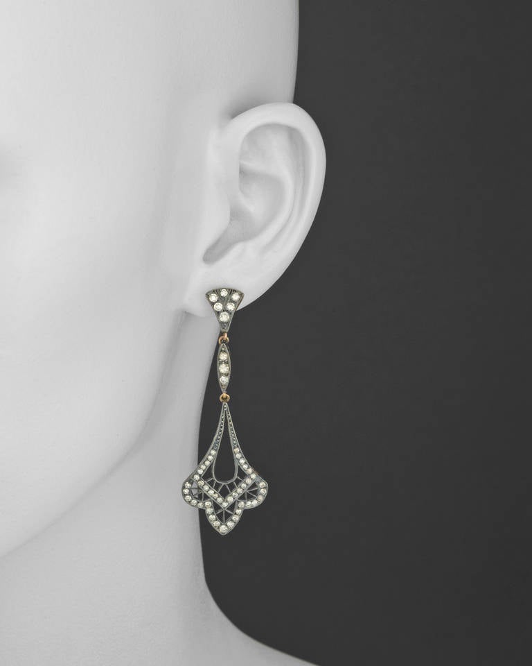 Antique-style diamond pendant earrings, accented by circular-cut diamonds weighing 1.74 total carats, mounted in pierced platinum-topped gold, with posts and friction backs. 2.5