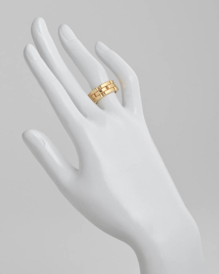 Panthere three-row band ring, composed of interlocking, polished 18k yellow gold links, numbered GS8596, signed Cartier. 8mm width band. Size 6 (52 - European).
