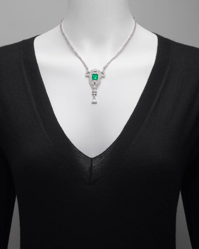 Edwardian emerald and diamond pendant necklace, the pendant centering on a fine, lightly included Colombian emerald weighing approximately 4.10 carats, within a geometric frame set with old European cut diamonds, suspending a kite-shaped diamond