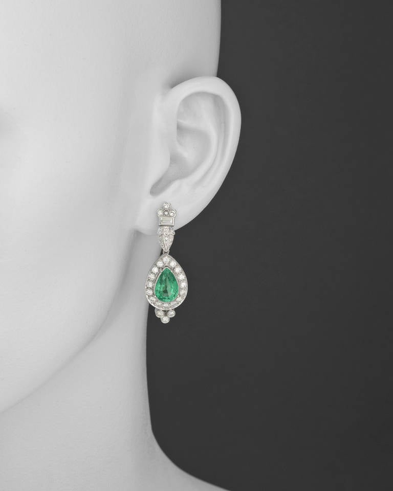 Emerald and diamond drop earrings, with two pear-shaped emeralds weighing approximately 5.40 total carats and diamonds weighing approximately 3.00 total carats, mounted in platinum, with post backs. 1.65