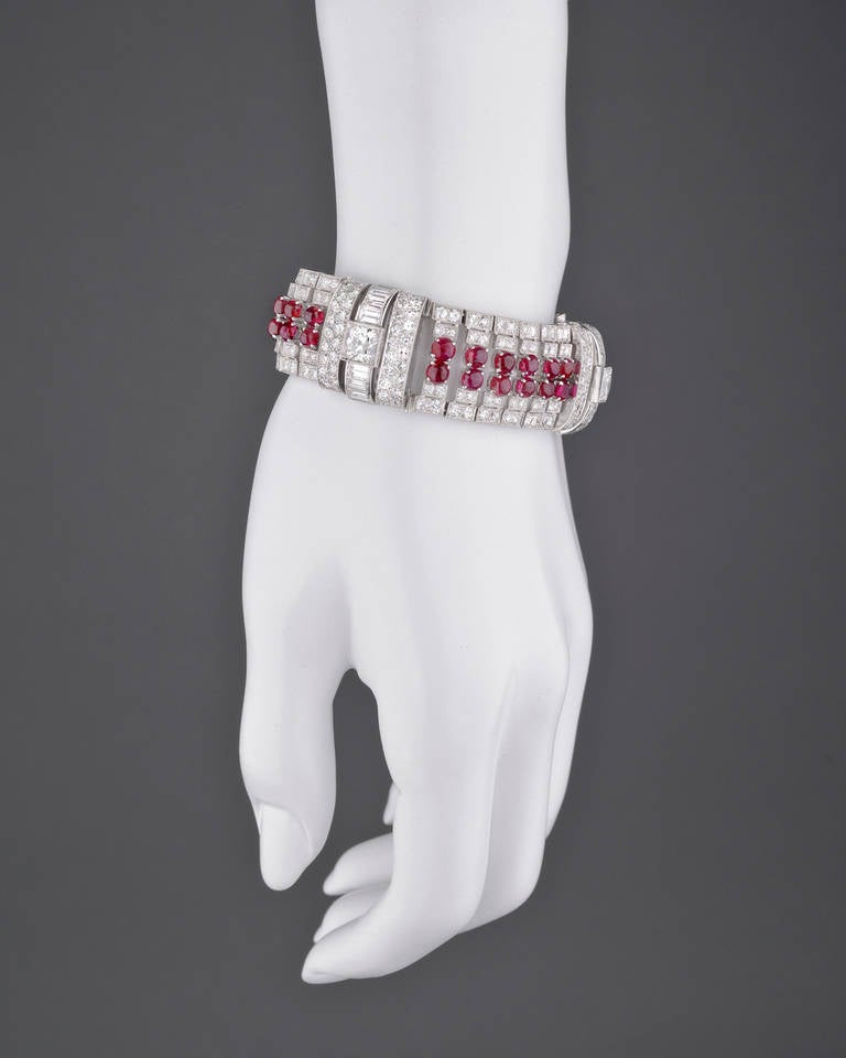 Ruby and diamond bracelet, centering on two lines of cabochon-cut rubies separated by three larger-sized antique cushion-cut diamonds, accented by circular-cut and baguette-cut diamonds, the 38 rubies weighing approximately 13.30 total carats, the