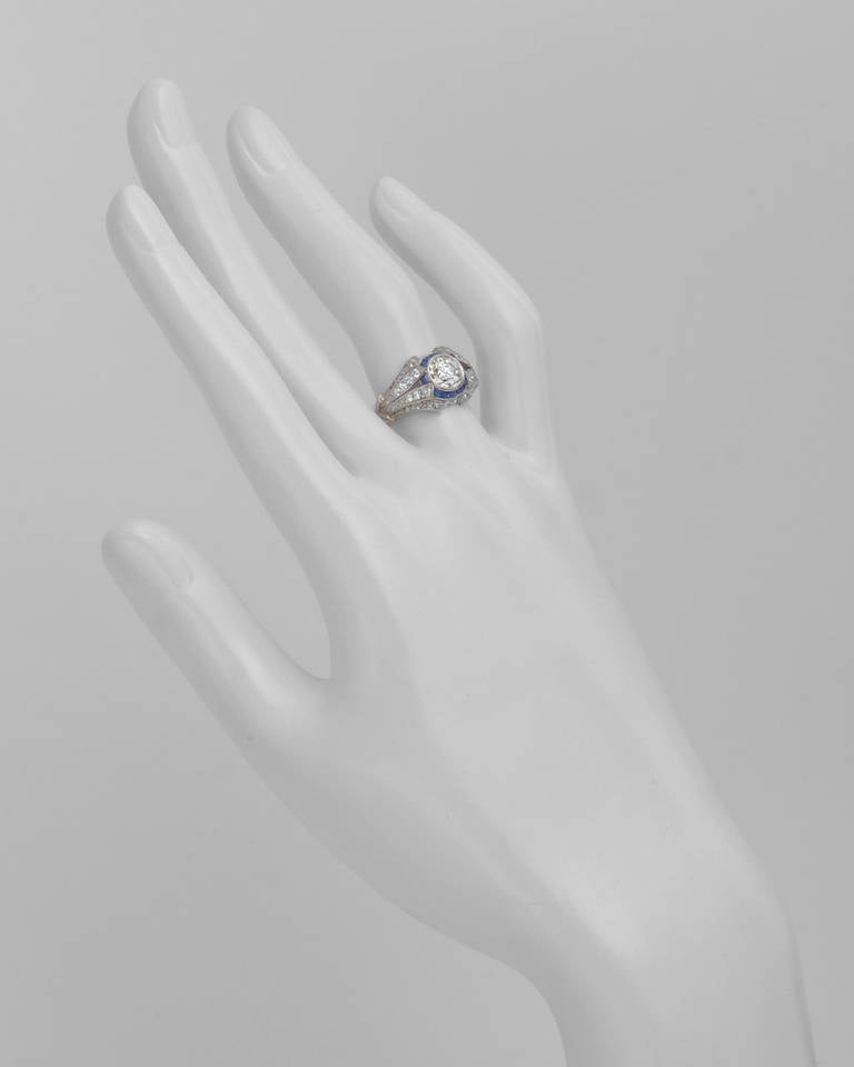 Antik-Stil Diamant und Saphir Kleid Ring:: in der Mitte eine größere alte Mine geschliffenen Diamanten mit einem Gewicht von ca. 1::00 Karat (J-K Farbe / SI Klarheit):: mit einem Kanal-Set Kaliber-Schliff Saphir umgeben:: um eine ausgefallene
