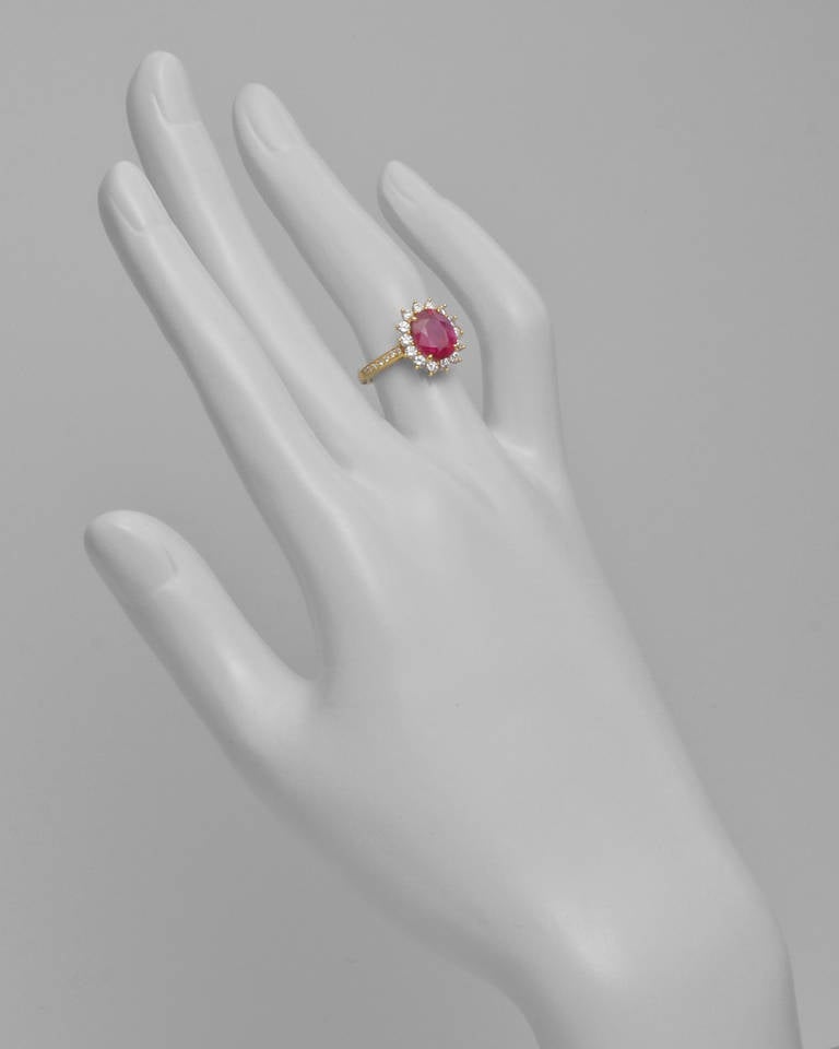 Ruby and diamond cluster ring, composed of an oval-cut ruby weighing approximately 1.95 carats and circular-cut diamonds weighing approximately 0.65 total carats, mounted in 18k yellow gold, with bead-set diamond shanks, signed Tiffany & Co. Size 5.