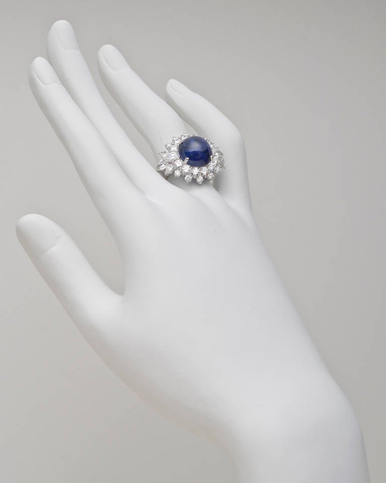 Burmese sapphire and diamond cluster ring, centering on a round cabochon-cut sapphire weighing 9.33 carats, with a round-cut and pear-shaped diamond surround, mounted in platinum. Re-sizable.

GRS-certified: NATURAL SAPPHIRE
Color: "Royal