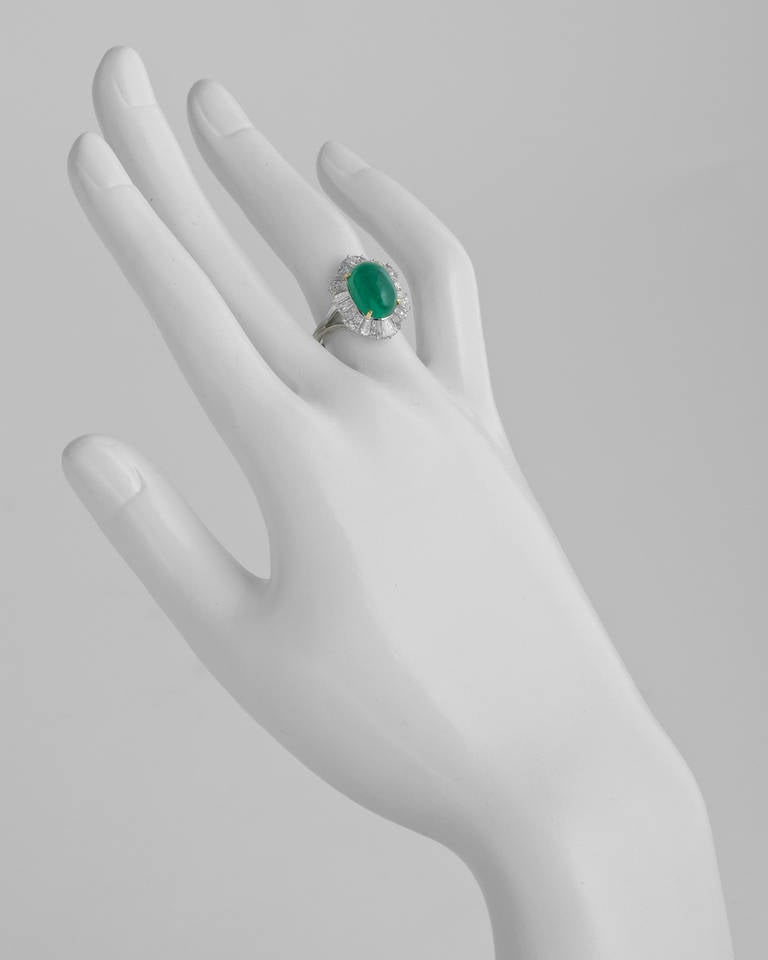 'Ballerina'-style emerald and diamond ring, centering on a natural cabochon-cut emerald weighing approximately 5.00 carats surrounded by twenty tapered baguette cut diamonds weighing approximately 3.20 total carats, mounted in platinum with yellow