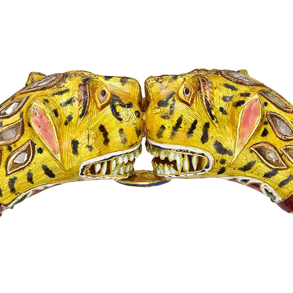 Bracelet, designed with adjoining tigers’ heads each applied with black and yellow Jaipur enamel, accented by foliate motifs in red, white and green enamel, enhanced by table-cut diamonds, mounted in gold, likely of Indian origin, and fitted to a