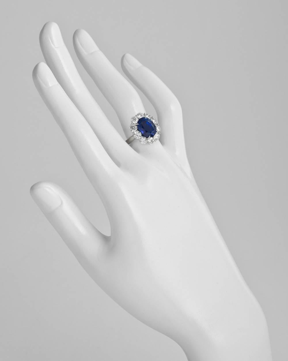 Sapphire and diamond cluster ring, centering a natural oval-shaped sapphire weighing 5.45 carats, with a round brilliant cut diamond surround, the ten diamonds weighing approximately 2.23 total carats, mounted in platinum. Accompanied by the GIA
