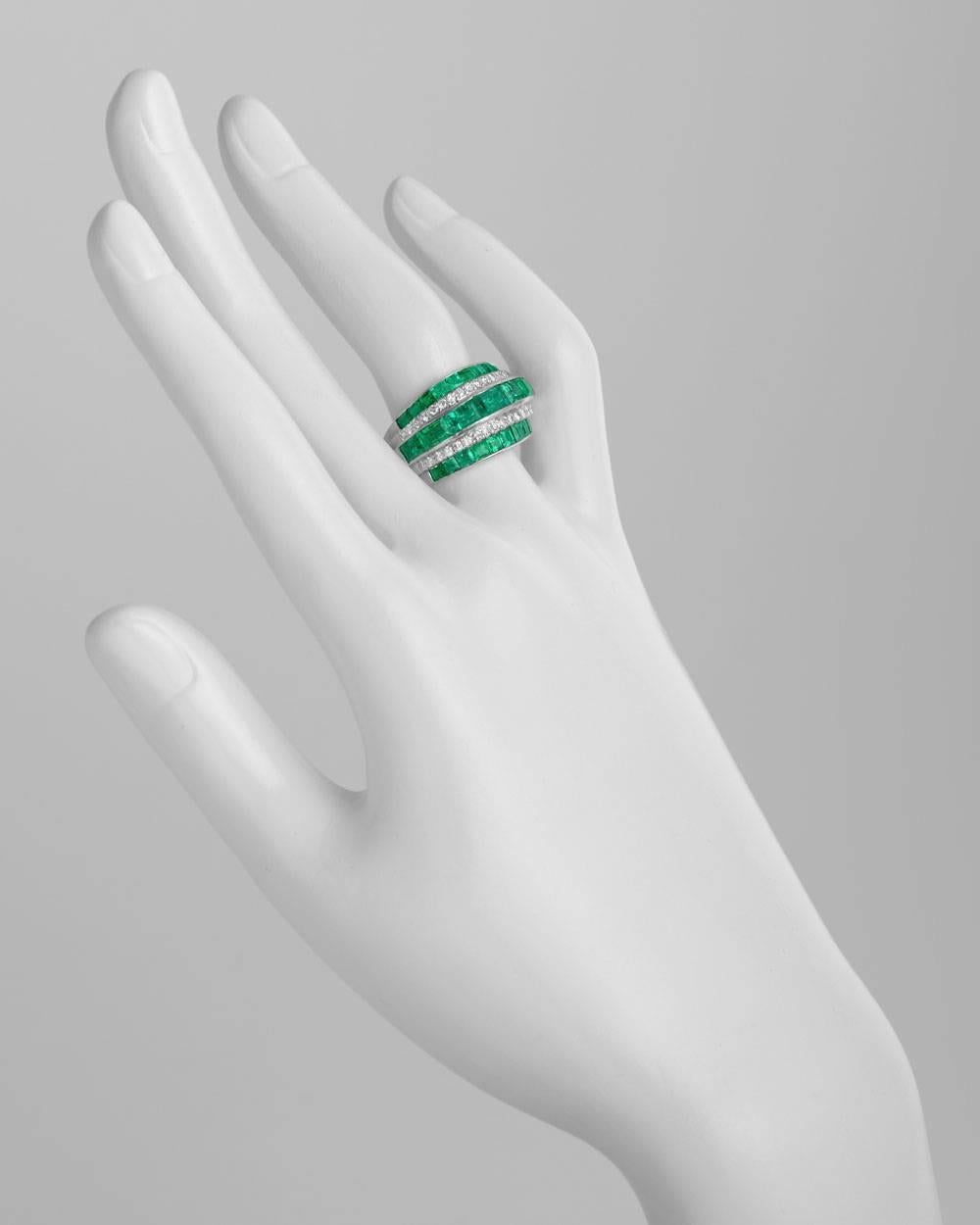 Emerald and diamond band ring, approximately halfway-set with three rows of baguette-cut and square-cut emeralds alternating with two rows of full-cut round diamonds, the diamonds weighing approximately 0.28 total carats, mounted in platinum. Size 8