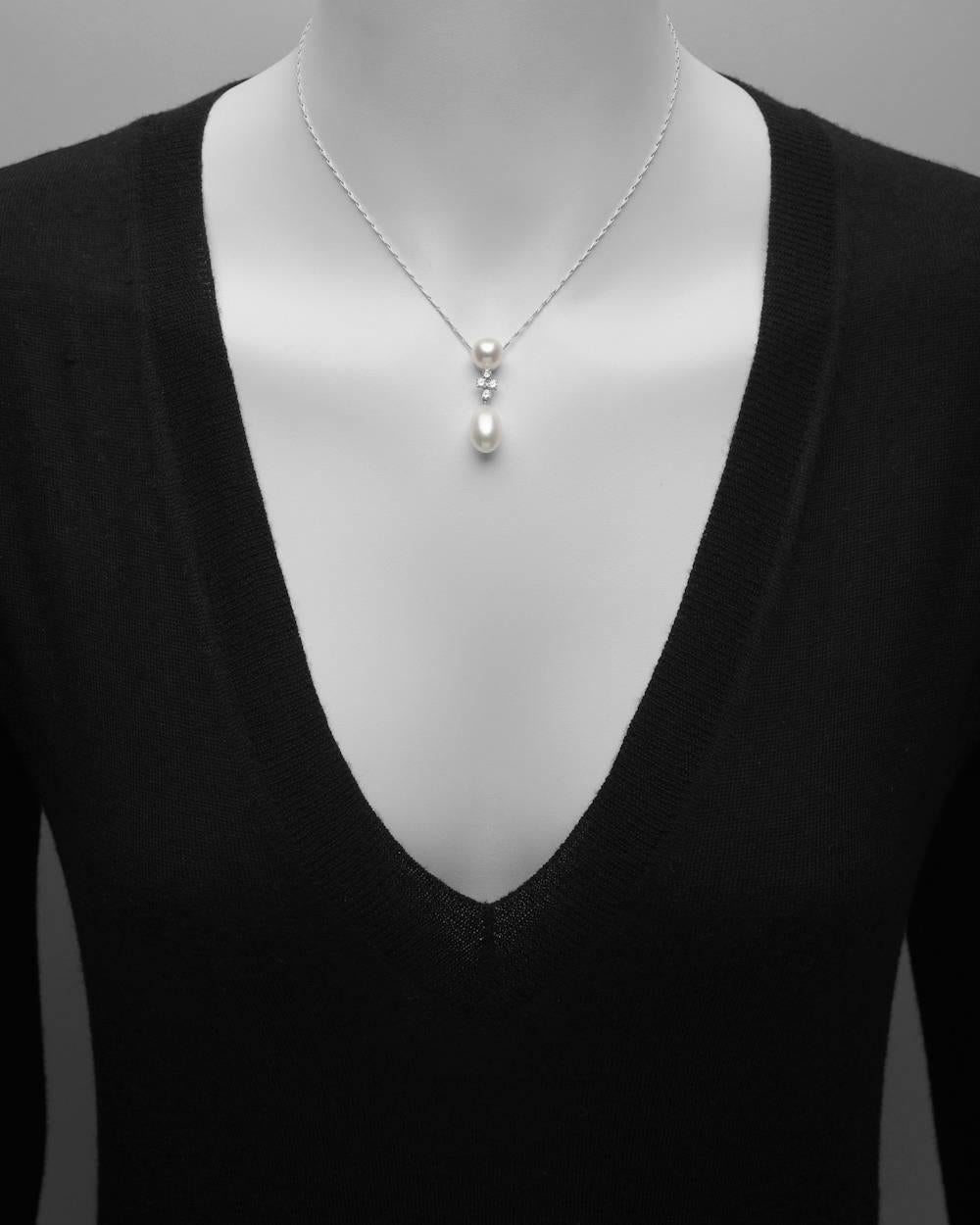 Cultured pearl and four diamond pendant with suspended freshwater pearl drop, all mounted in platinum, on a fancy drawn-link platinum chain with spring-ring clasp. Round pearl measuring 9.1mm, drop-shaped freshwater pearl measuring 14.7mm x 9mm,