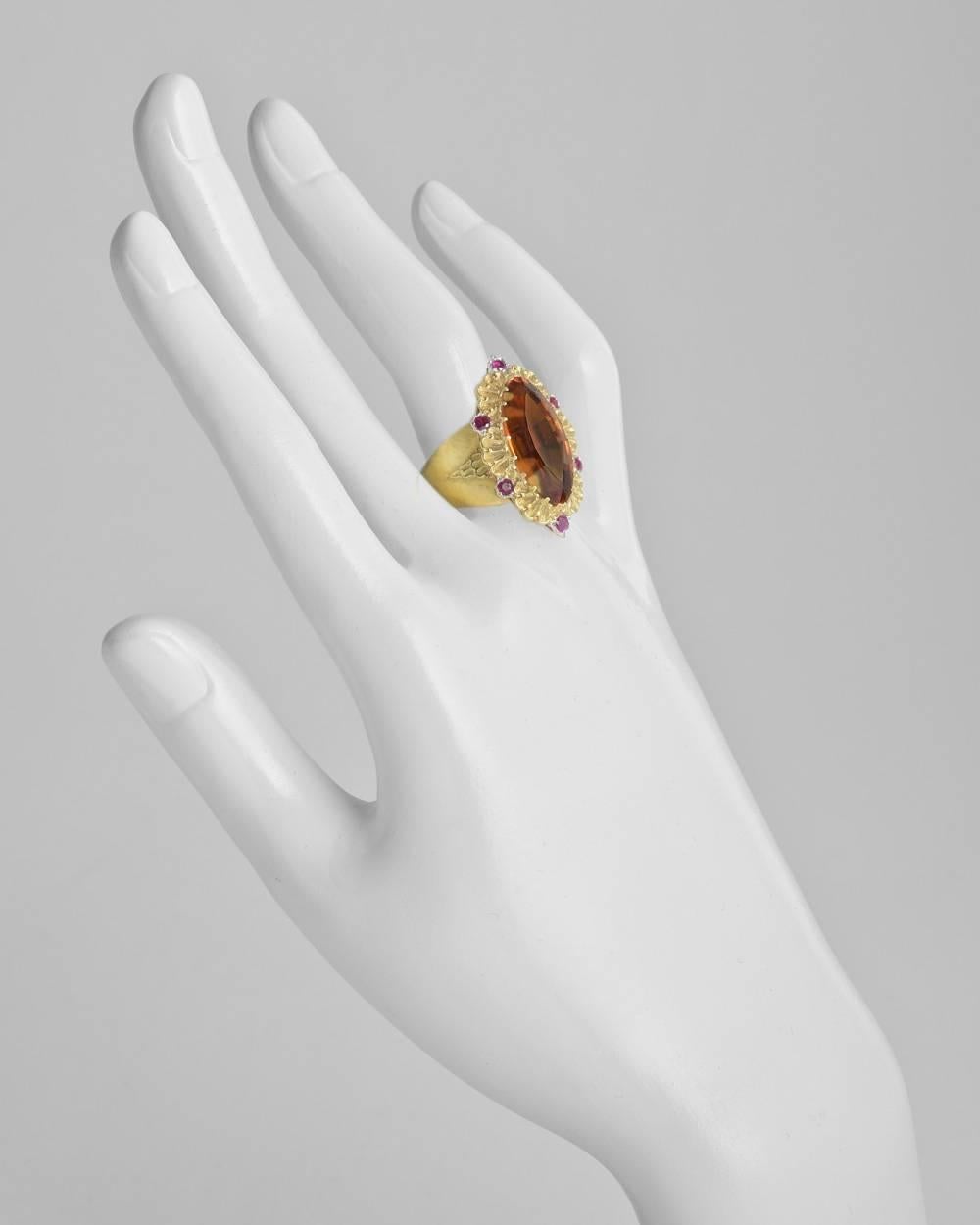 Cocktail ring, showcasing a large navette-cut Madeira citrine surrounded by six round faceted rubies weighing approximately 0.30 total carats, mounted in an elegantly engraved and textured 18k yellow and white gold setting, signed Buccellati. Ring