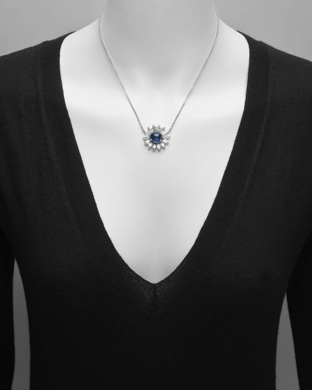 Sapphire and diamond cluster pendant necklace, showcasing an oval-shaped cabochon sapphire weighing approximately 7 carats, surrounded by near-colorless marquise-shaped diamonds weighing approximately 3.50 total carats (I-J color/SI clarity),