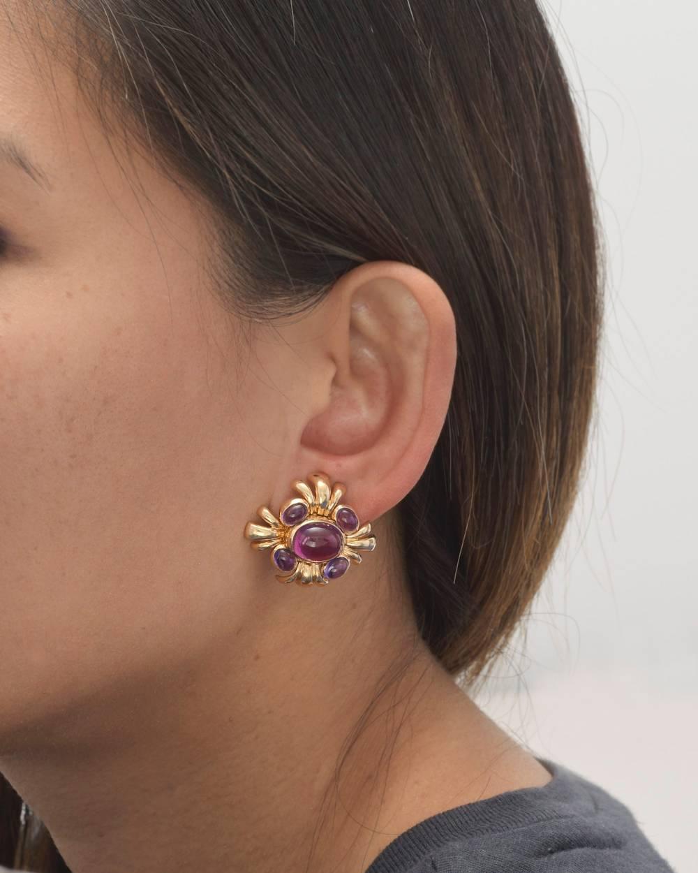 'Cabana' earclips, centering a larger oval cabochon-cut pink tourmaline, flanked by four smaller oval cabochon-cut amethysts, mounted in 18k yellow gold, with clip backs, signed Verdura. 1