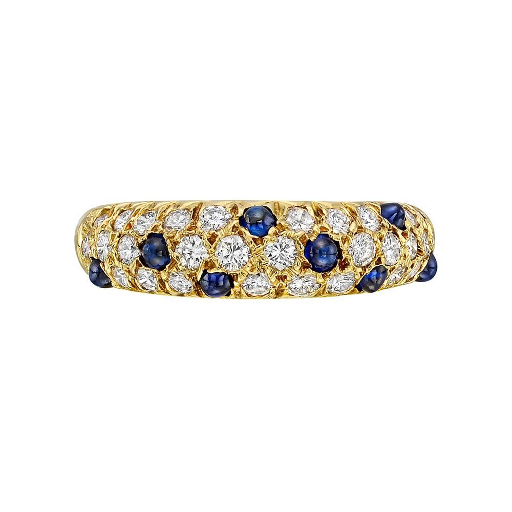 Diamond and sapphire domed ring, set with circular-cut diamonds and cabochon-cut sapphires approximately halfway around the band, mounted in polished 18k yellow gold, numbered NV4076, signed Van Cleef & Arpels. Diamonds weighing approximately 0.87