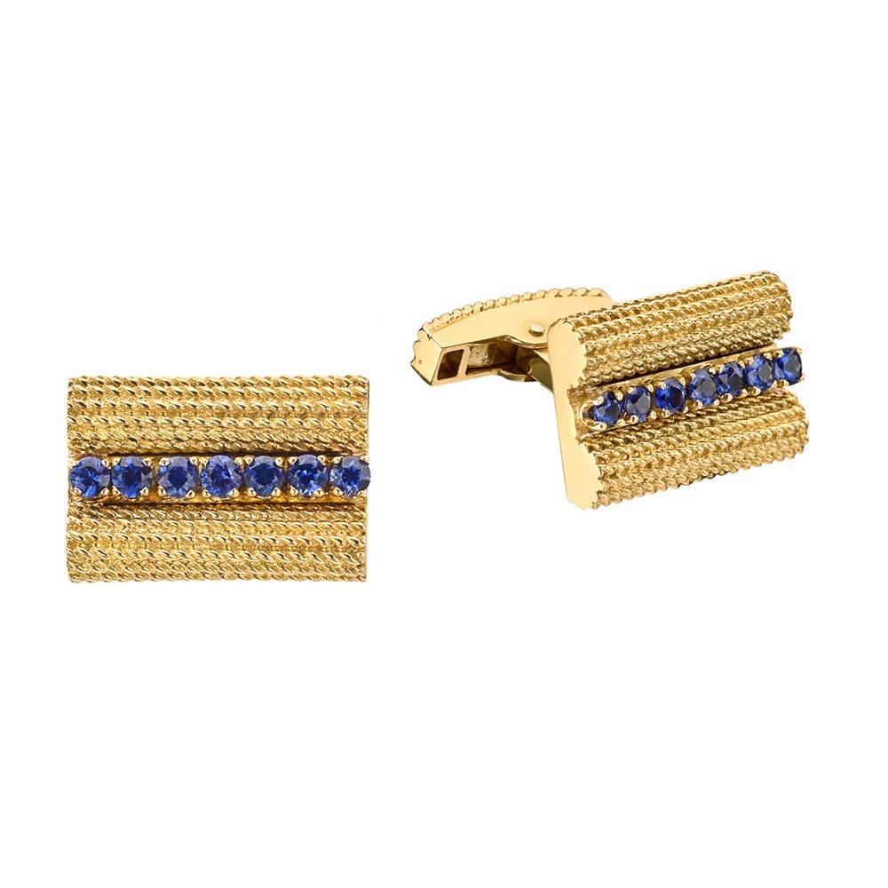 Gold and sapphire cufflinks, featuring a single row of circular-cut sapphires set into a rectangle of woven, herringbone-patterned 18k yellow gold, with leverbacks, circa 1950s, signed Tiffany & Co. Accompanied by Tiffany cufflinks box. Front link