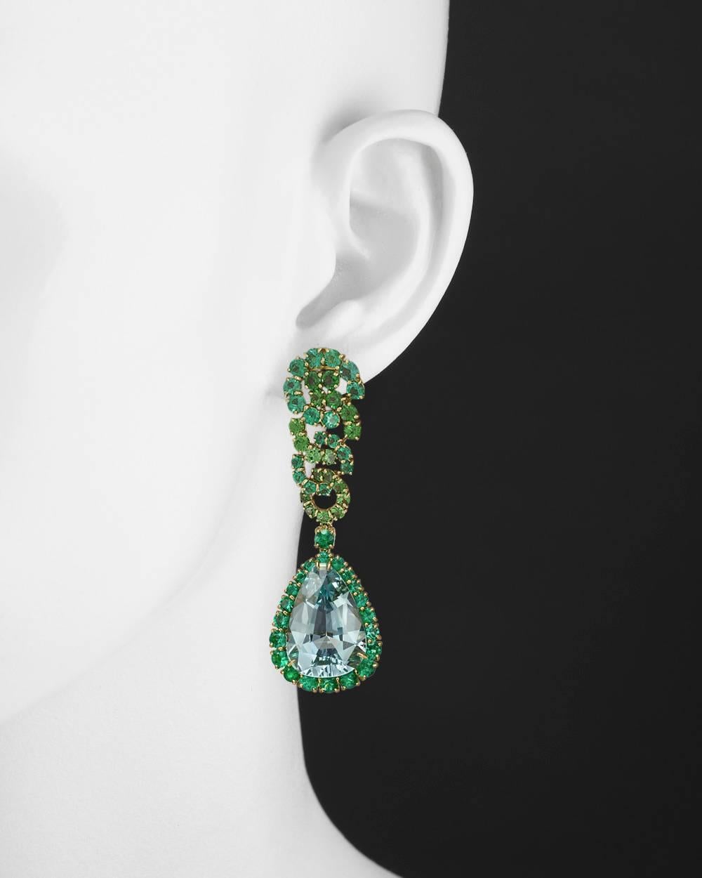 "Cascade" earrings, showcasing a larger pear-shaped aquamarine, accented by circular-cut emeralds and tsavorite garnets, in 18k yellow gold, signed Verdura. Clip backs. 2.5" length and 0.8" width at widest point.
