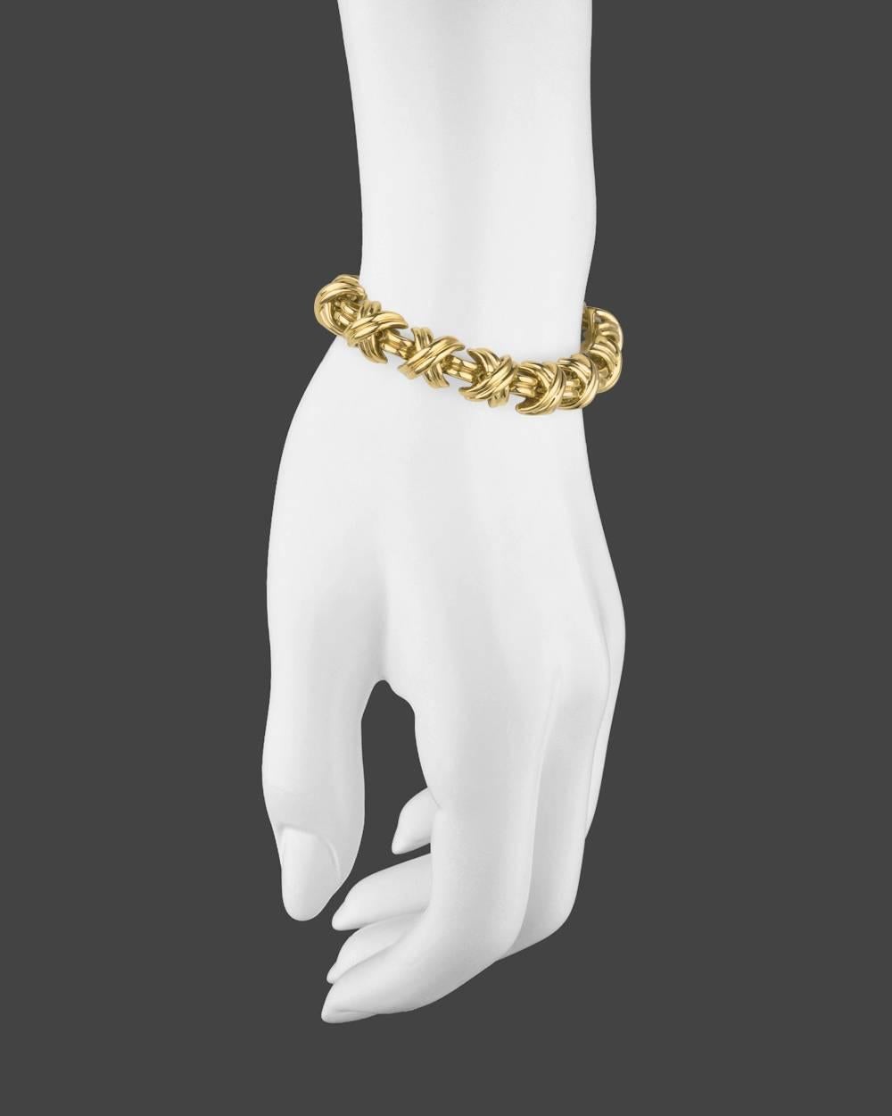 "Signature" link bracelet, composed of 'X'-motif links in polished 18k yellow gold, secured by a box clasp with safety catch, stamped 'T&CO' for Tiffany & Co. 7.25" long and 0.4" width. 47.32 grams.
