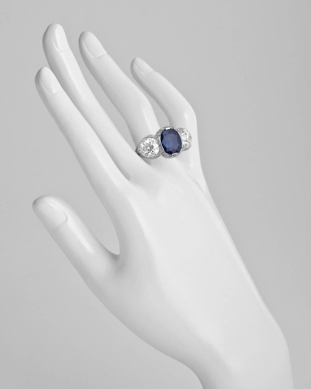 Antique sapphire and diamond three-stone ring, centering an oval-shaped sapphire weighing 5.23 carats, flanked by two circular-cut diamond shoulders weighing approximately 2.20 and 2.60 carats respectively (I and J color, both with VS2 clarity or