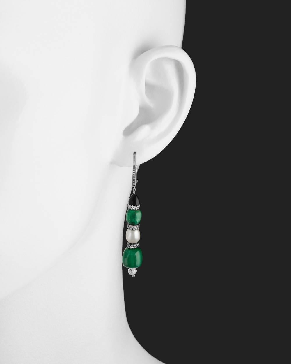 Chain drop earrings, showcasing four natural emerald beads and two natural pearls separated by diamond-set rondelles, with faceted diamond beads at base and black onyx cap surmounts, in platinum. The earrings suspended from diamond-set wires with