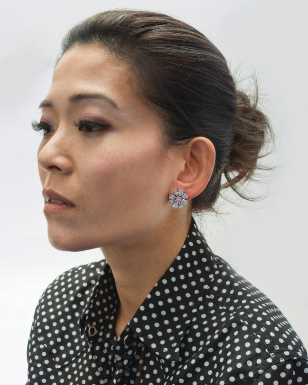 Diamond flower cluster earrings, showcasing an emerald-cut fancy intense pink diamond surrounded by eight colorless pear-shaped diamonds, mounted in platinum, attributed to Martin Katz. Two pink diamonds weighing 1.52 total carats and sixteen