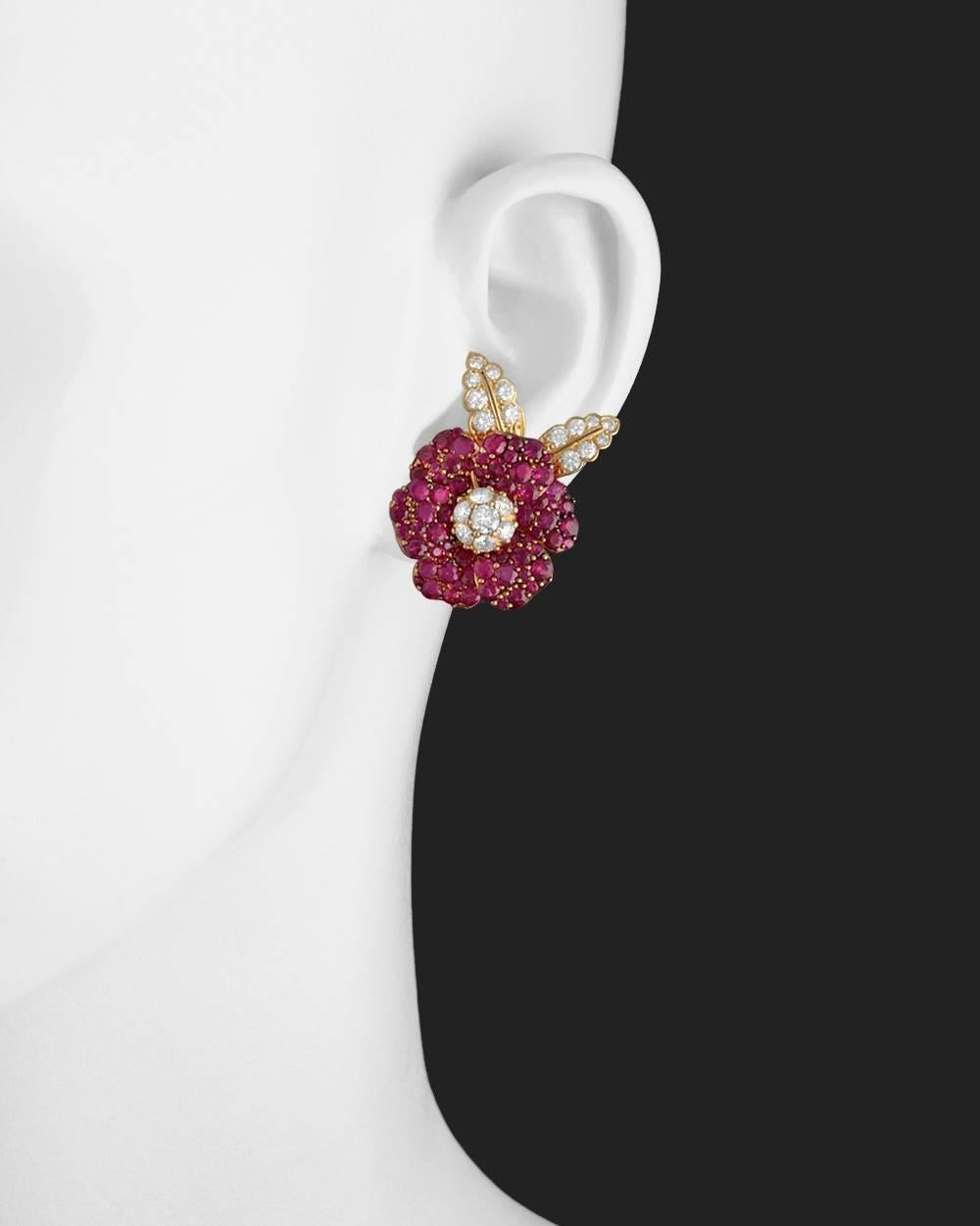 Flower earrings, showcasing pavé-set round ruby petals surrounding a round brilliant-cut diamond cluster center with pavé-set round diamond leaves, in 18k yellow gold. Rubies weighing approximately 10.00 total carats and diamonds weighing