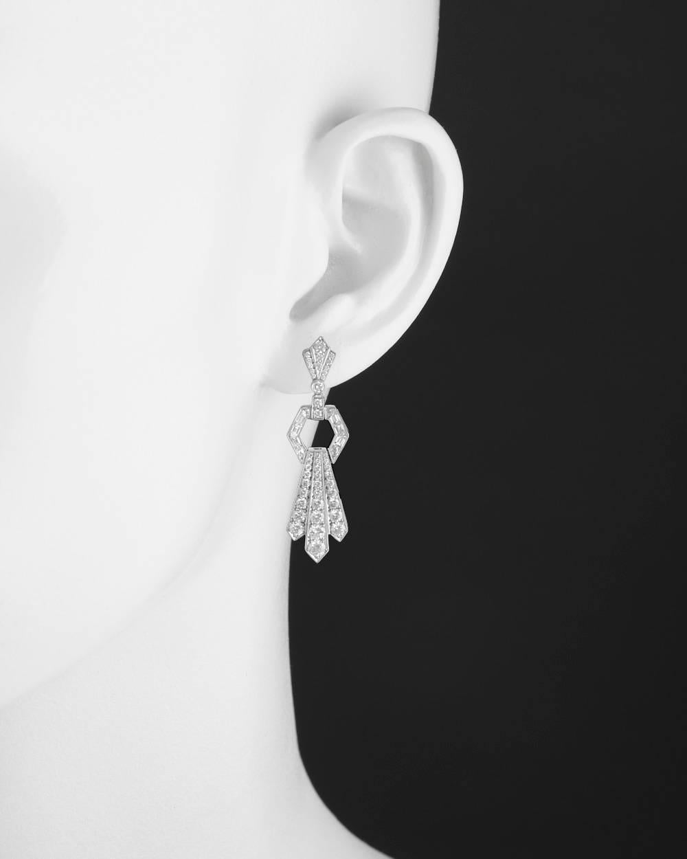 Art Deco-style door knocker drop earrings, composed of finely articulated links set with round-cut and calibre-cut diamonds altogether weighing 2.86 total carats, in platinum. Posts with friction backs for pierced ears. 1.5