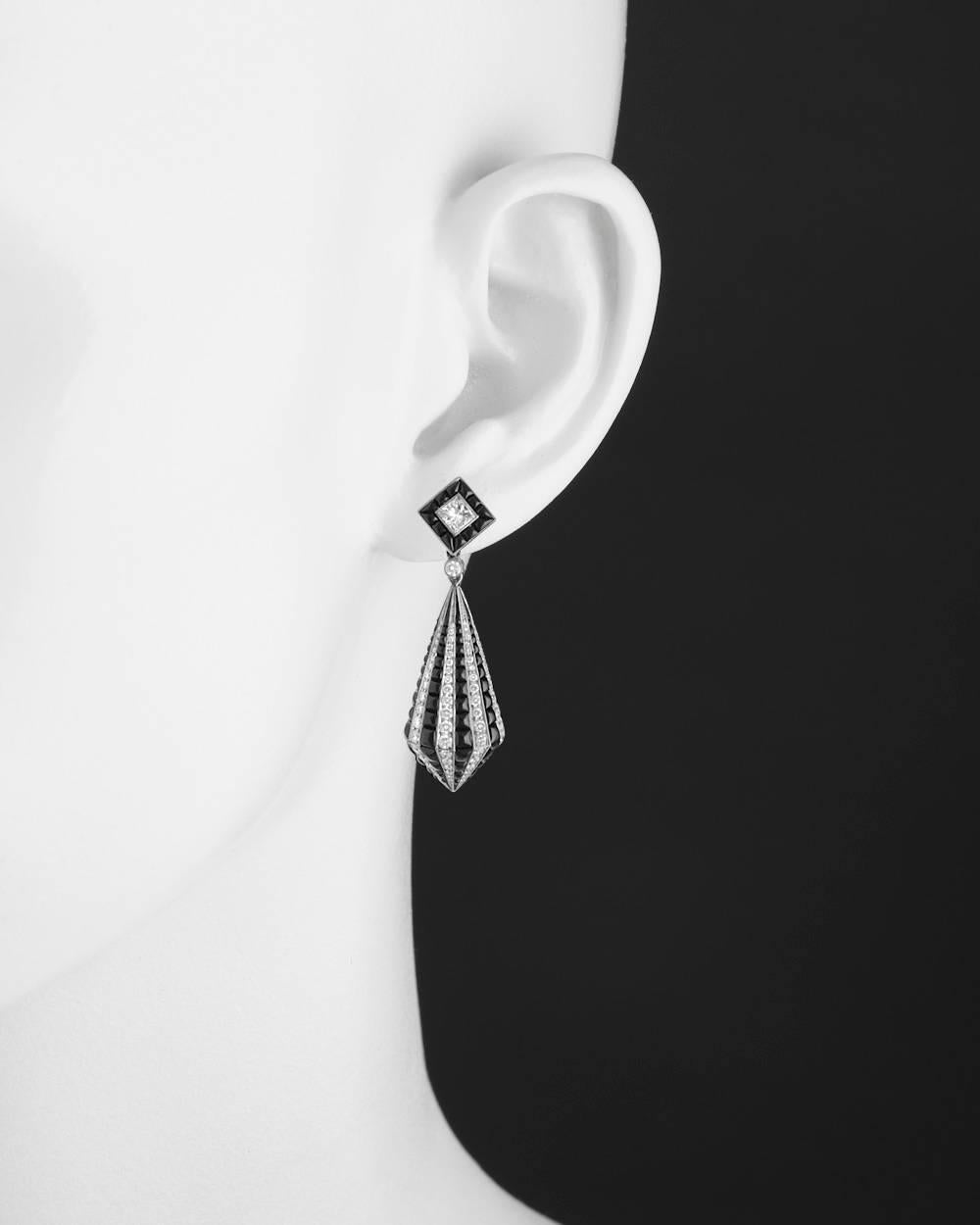 Drop earrings, featuring an elongated kite-shaped drop set with alternating vertically-set 'stripes' of graduated round brilliant-cut diamonds and cabochon-cut black onyx, suspended from a square-shaped surmount centering a square-cut diamond framed